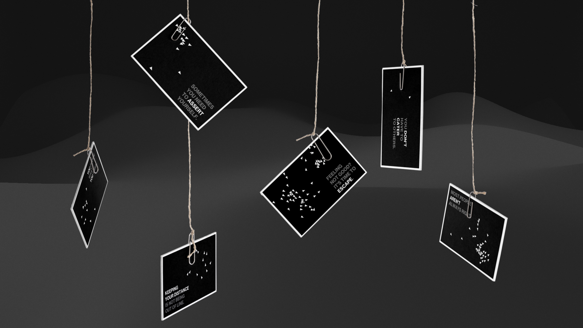 Black statement cards from GROUPTHINK hanging on strings with paperclips