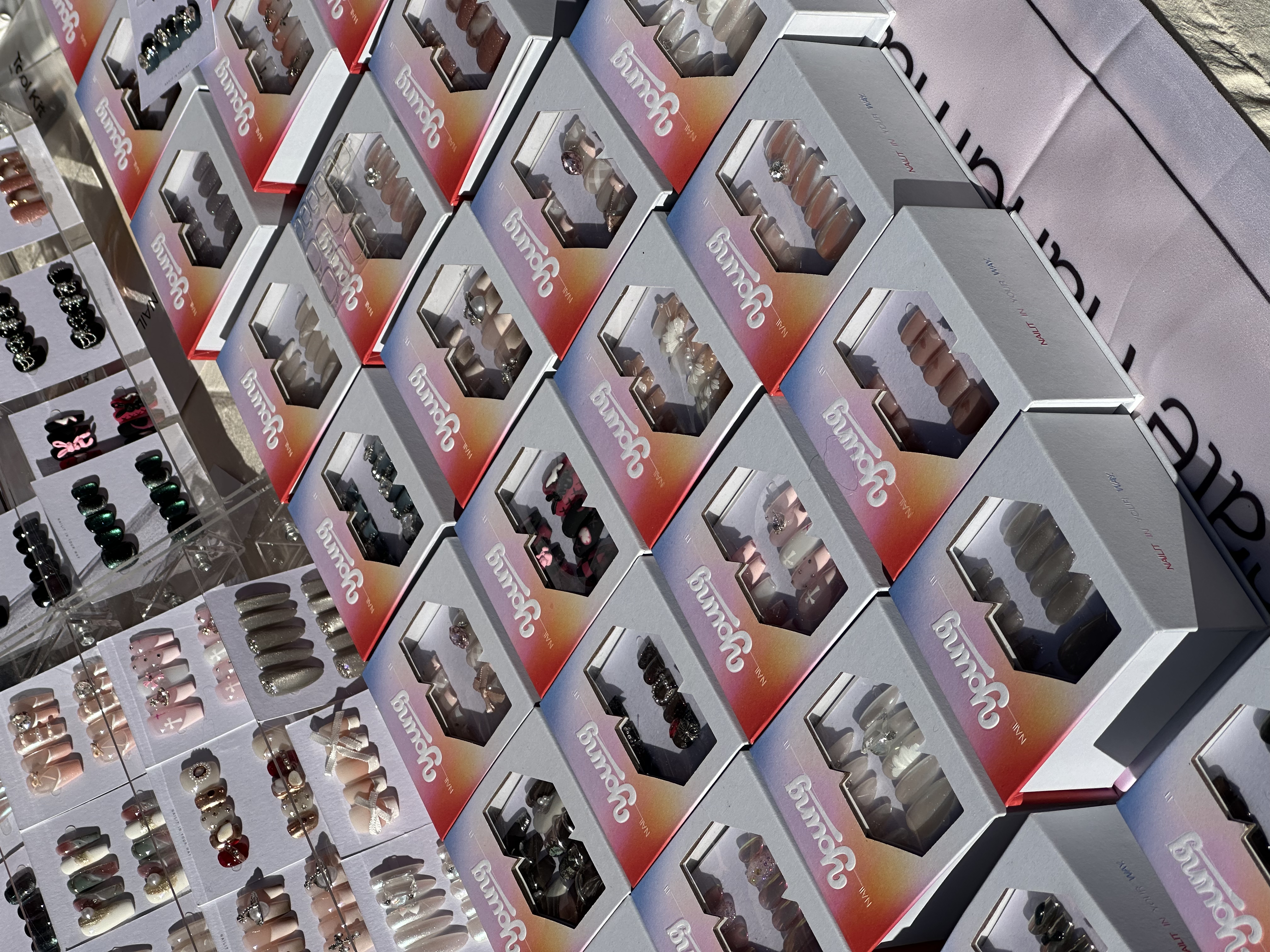 A full display of NAILIT Young boxes and press-on nail sets